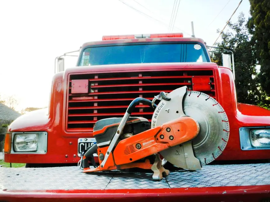 Focused shot of a concrete saw on a red firetruck, showcasing emergency rescue tools.